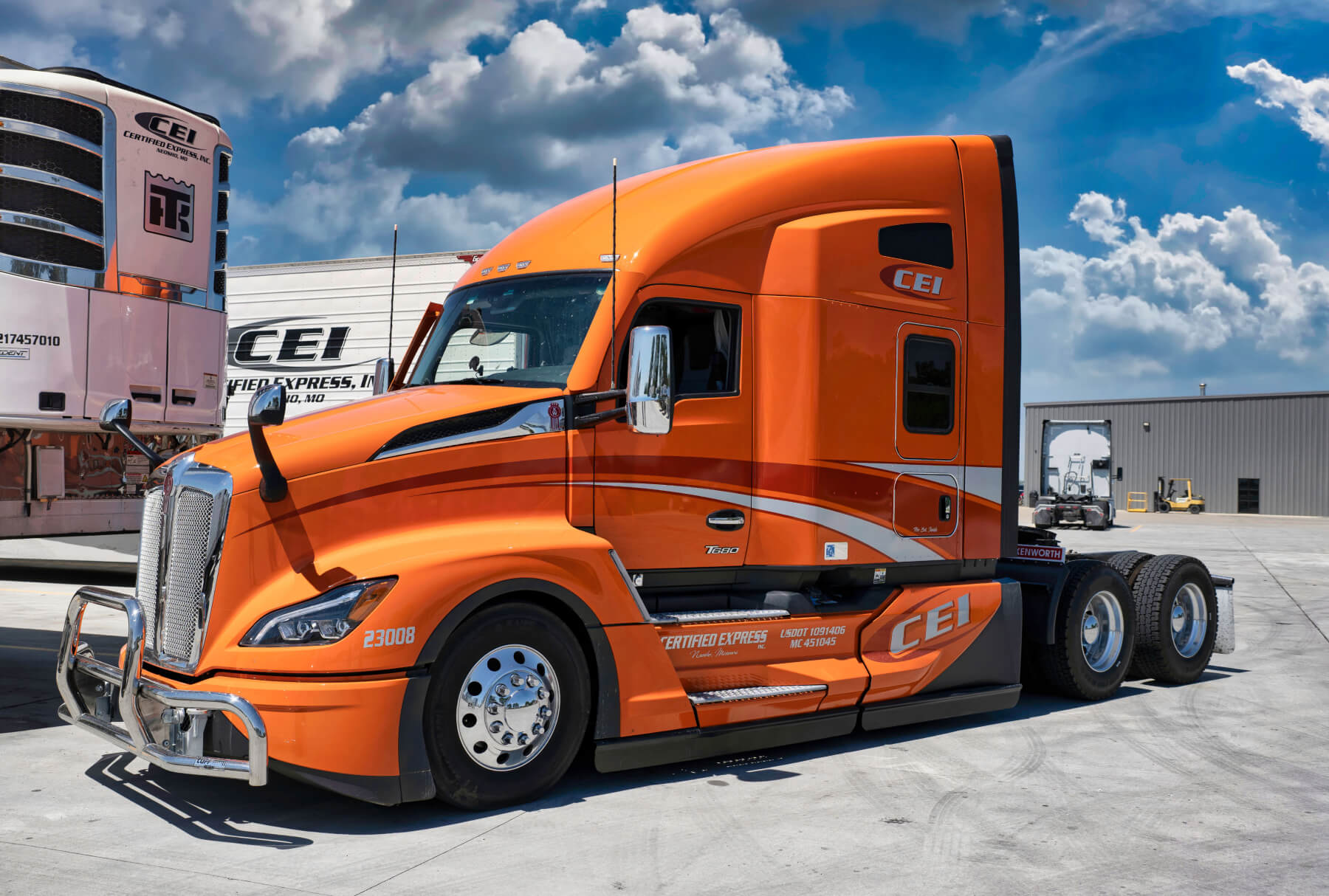 Orange CEI truck cab without trailer is parked in the CEI lot.