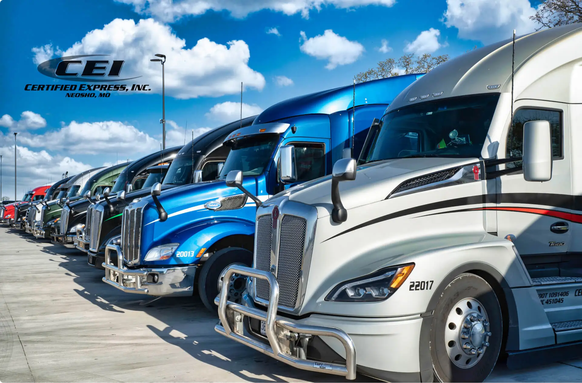 A row of CEI semi truck cabs parked beside each other disappears into the background.